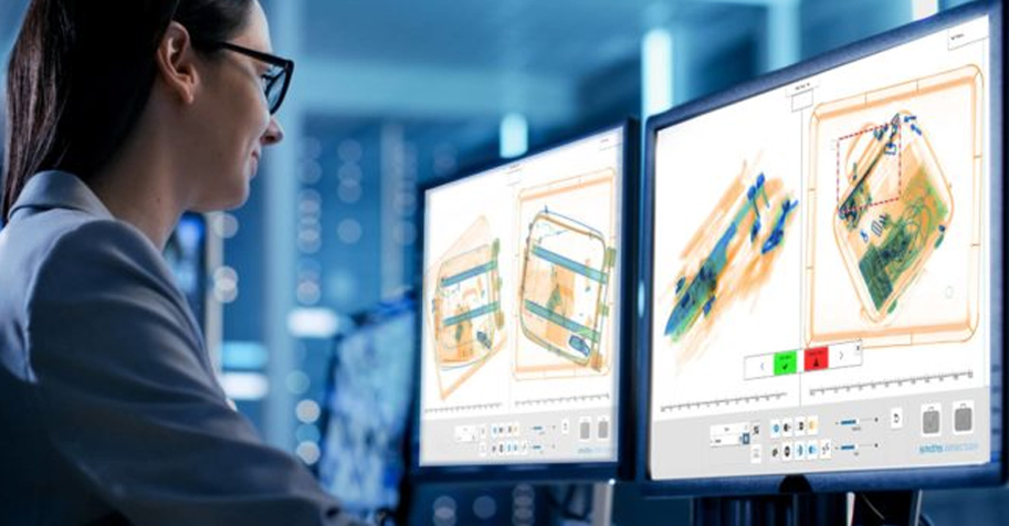 TSA agent analyzing X-ray images of luggage